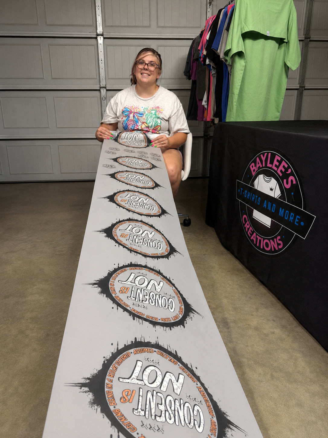 Finished custom DTF gang sheet with repeating graphic design, printed and held up in Baylee's Creations shop